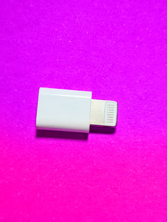 Isolated photo from a USB lightning apple OTG driver (On the go). This OTG is white and sits on a pink background.の写真素材