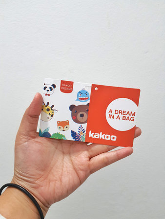 West Java, Indonesia in January 2023. Isolated white photo of a hand holding the KAKOO product brand...