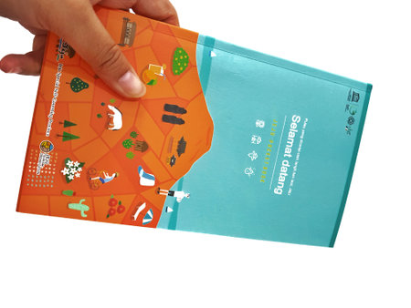 Jakarta, Indonesia in May 2022. A hand is holding a welcome guide book for travelers on vacation on Jeju Island, the JEJU POCKET BOOK. Which contains recommendations for tourist spots, culinary, attractions, tours and various other information.のeditorial素材