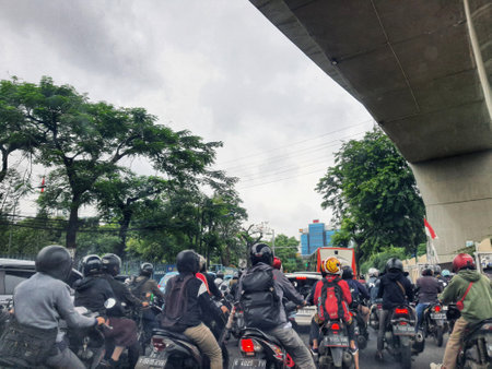 Jakarta, Indonesia in July 2022. There is a traffic jam under the Becakayu Toll Road, where motorbikes are stopping and moving slowly.のeditorial素材