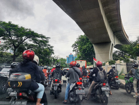 Jakarta, Indonesia in July 2022. There is a traffic jam under the Becakayu Toll Road, where motorbikes are stopping and moving slowly.のeditorial素材