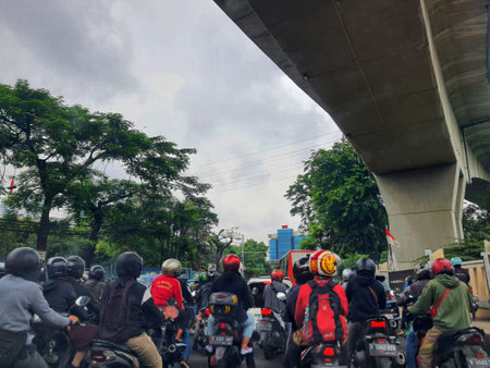 Jakarta, Indonesia in July 2022. There is a traffic jam under the Becakayu Toll Road, where motorbikes are stopping and moving slowly.のeditorial素材