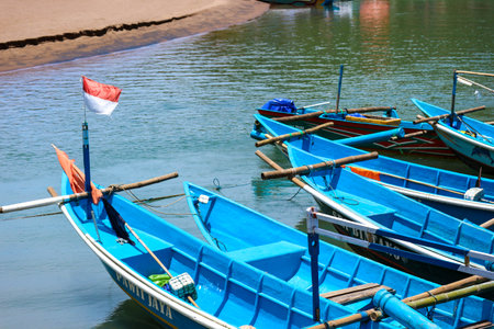 Yogyakarta, Indonesia in October 2022. Local tourists enjoying Baron beach, Gunung Kidul. They boarded a blue tour boat to circle this beach.のeditorial素材