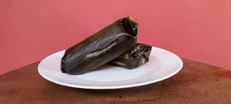 Arem-arem is a typical Central Javanese food in the form of rice containing tempeh sauce or meat fried chili sauce or containing vegetables wrapped in banana leaves.の写真素材