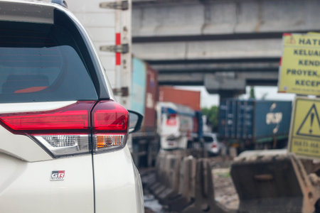 Close up photo of a back lamp of car that stuck in a traffic jam on the highway, with a bokeh background.の写真素材