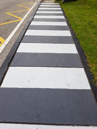 Covered concrete ditches or u-ditch ditches used as pedestrian crossings are painted white and black to indicate the area to pedestrians.の写真素材