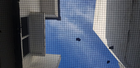The background photo of the sky which has wire mesh and white houses. Very random photos of the scenery at home.の写真素材