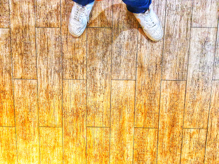 A pair of white shoes on a floor with a wooden texture. Copy space, negative space. Perfect for your templates.の写真素材