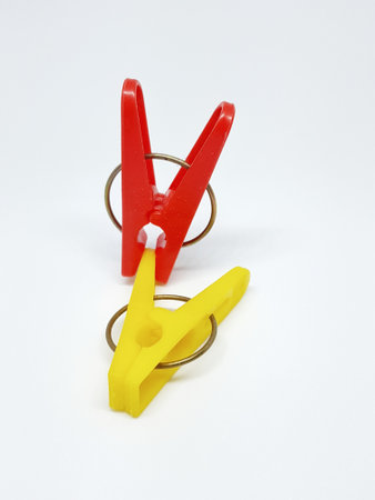 Isolated photo of clothespins in red and yellow with very contrasting colors. With a white background.の写真素材