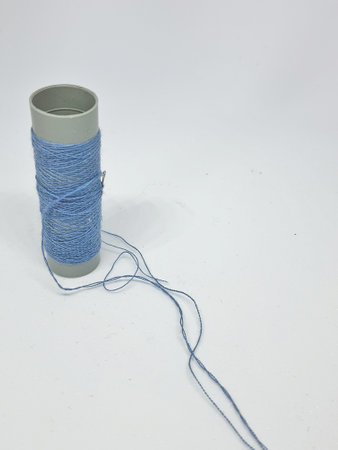 Isolated white photo of a blue sewing thread. With copy space.の写真素材