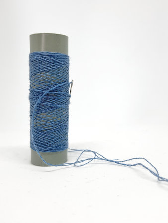Isolated white photo of a blue sewing thread. With copy space.の写真素材