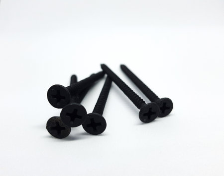 An isolated white photo of six black bolts with sharp edges that will be used to mount a shelf on the wall.の写真素材