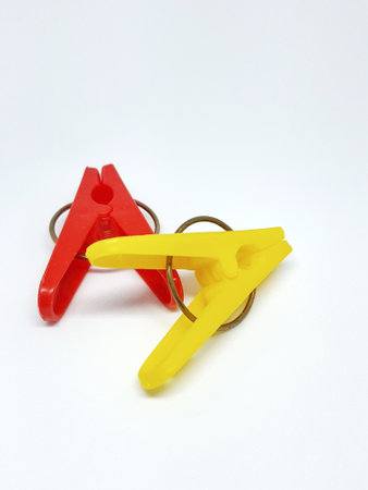 Isolated photo of clothespins in red and yellow with very contrasting colors. With a black white background.の写真素材