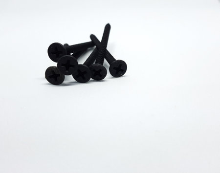 An isolated white photo of six black bolts with sharp edges that will be used to mount a shelf on the wall.の写真素材