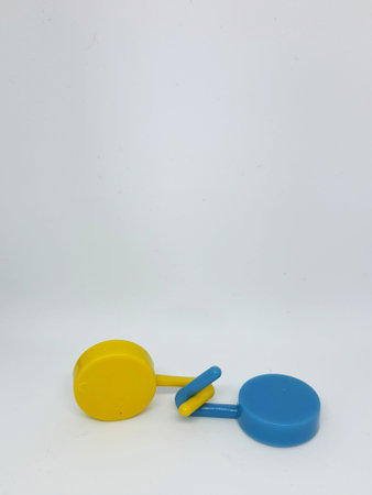 Two round blue and yellow clothes hook hangers that go hand in hand. Isolated white's photo.の写真素材