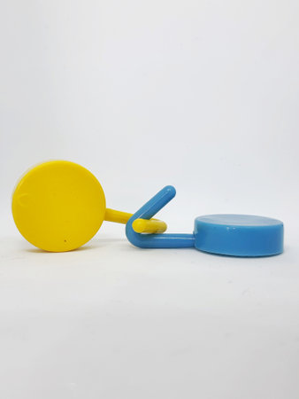 Two round blue and yellow clothes hook hangers that go hand in hand. Isolated white's photo.の写真素材