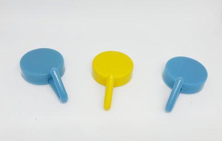 Isolated white photo of three round coat hangers with blue and yellow colors. Two blue one yellow.の写真素材