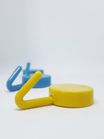 Isolated white photo of three round coat hangers with blue and yellow colors. Two blue one yellow.の写真素材