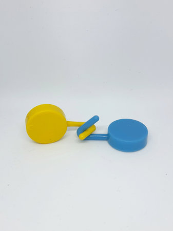 Two round blue and yellow clothes hook hangers that go hand in hand. Isolated white's photo.の写真素材