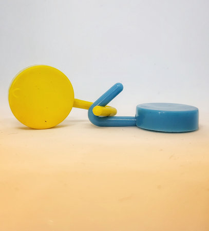 Two round blue and yellow clothes hook hangers that go hand in hand. Isolated white's photo.の写真素材