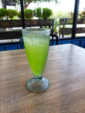 A glass of iced melon lemonade. Fresh orange juice with sweet melon syrup. A very delicious and refreshing blend to drink on a hot day. This ice is green.の写真素材