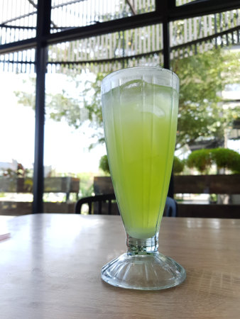 A glass of iced melon lemonade. Fresh orange juice with sweet melon syrup. A very delicious and refreshing blend to drink on a hot day. This ice is green.の写真素材