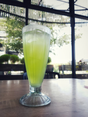 A glass of iced melon lemonade. Fresh orange juice with sweet melon syrup. A very delicious and refreshing blend to drink on a hot day. This ice is green.の写真素材