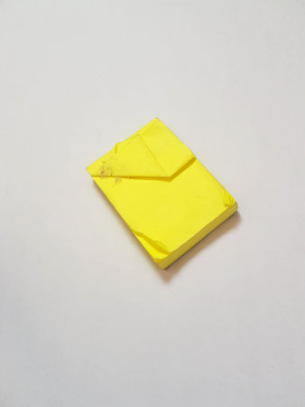 Isolated white photo of a sticky note in dirty and worn condition. These sticky notes are yellow in color.の写真素材