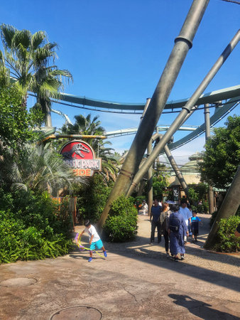 Osaka, Japan on September 30, 2023. Visitors to Universal Studios Japan are passing under the track of the Jurassic Park The Flying Dinosaur roller coaster. This incredibly long, state-of-the-art flying coaster features unimaginable ascents and drops.のeditorial素材