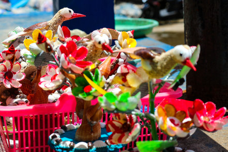 Beach souvenirs, craft miniature birds and flowers made from colorfully painted shells. Very pretty...