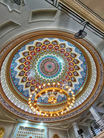 A stunning view of a mosque's dome, adorned with intricate calligraphy and vibrant colors.  A grand chandelier hangs beneath, adding to the majestic atmosphere.の写真素材
