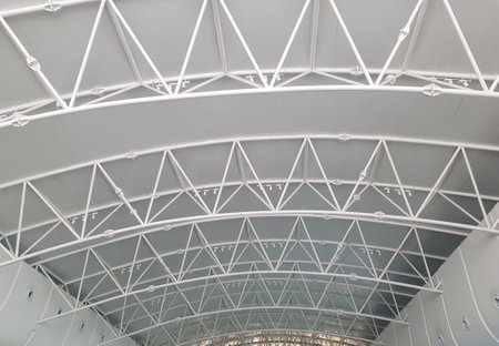 Modern architectural detail showcasing a white steel truss ceiling structure with geometric patterns Perfect for industrial or modern design inspiration.の写真素材