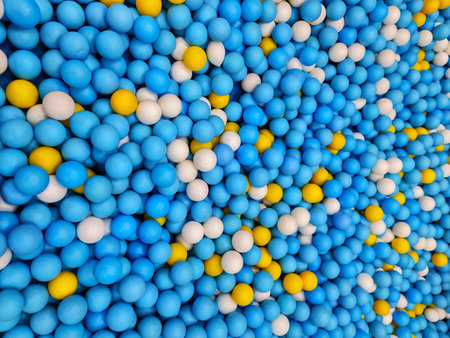 An overhead shot of a ball pit shows a colorful mix of blue white and yellow balls perfect for...