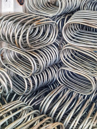 Pile of curved metal rods creates a structured abstract pattern Industrial usage and metalwork...