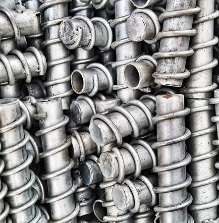 Pile of metal pipes with coiled wraps creates an industrial feel and conveys a sense of structural...