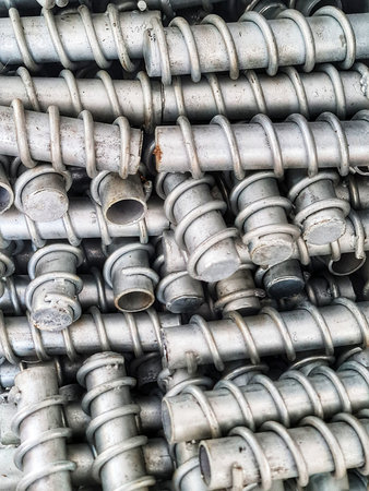 Close-up view of stacked metal ground anchors shows industrial design and sturdy construction, perfect for engineering and construction projects visuals.の写真素材