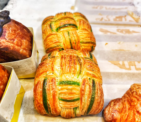 Delicious pastries with golden brown crusts and green filling are displayed on a bakery tray perfect for food blogs or culinary projects.の写真素材