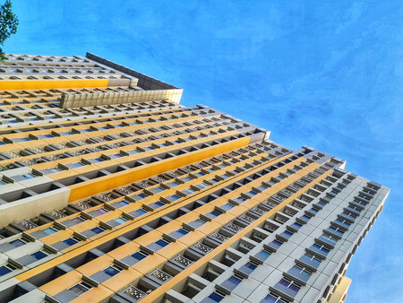 Tall building stretches upward toward a vibrant blue sky with interesting architectural details...