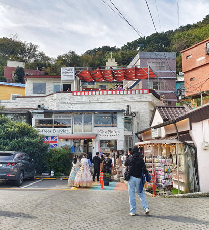 Busan, South Korea on 8 Nov 2024. Bustling village street features unique architecture, several restaurants with patrons, and people walking about, bathed in soft daylight offering a lively yet relaxed atmosphere ideal for travel and lifestyle content.のeditorial素材