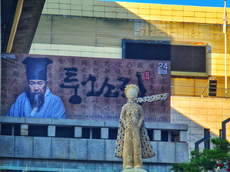 Seoul, South Korea on 10 Nov 2024. Sculpted figure stands before an artistic monument and building with traditional script, offering an urban cityscape scene for cultural and travel marketing.のeditorial素材