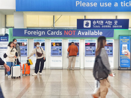 Seoul, South Korea on 10 Nov 2024. Travelers using ticket machines with clear signage at a bright, modern train station, creating a busy atmosphere, perfect for travel and public transport related content.のeditorial素材