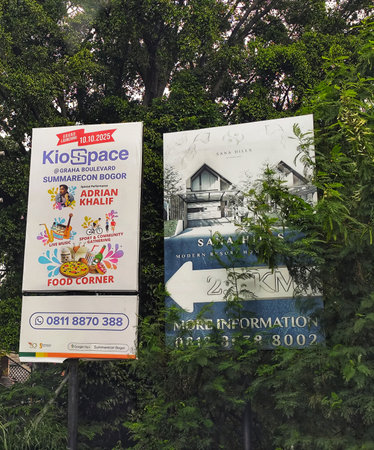 Bogor, Indonesia on 25 Oct 2025. Advertisement board in green setting features event announcements and real estate details, creating an inviting atmosphere for business or lifestyle-themed marketing materials.のeditorial素材