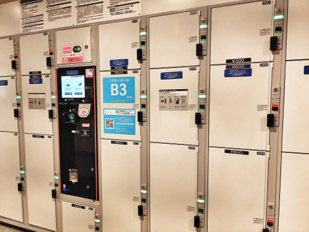 Tokyo, Japan on 20 Oct 2025. Row of public lockers, predominantly white, features a digital payment terminal, labeled doors, and integrated locking mechanisms, suggesting a convenient storage solution for travelers and commuters in urban areas.のeditorial素材