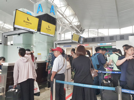 Hanoi, Vietnam on 16 May 2025. Several people are waiting in line at the check-in counter for an...
