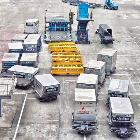 Various pieces of airport ground equipment and cargo containers are arranged on the tarmac in...