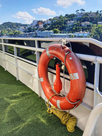 Istanbul, Turkey on 12 July 2022. Bosphorus. An orange life ring hangs on the deck of a boat, with a...