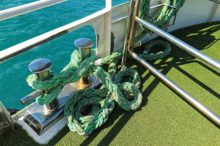 Istanbul, Turkey on 12 July 2022. Green rope secures a boat to its mooring cleat with the turquoise...