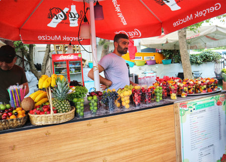 Istanbul, Turkey on 12 July 2022. A vendor stands at his fruit stand offering fresh fruit, smoothies, and juices at an outdoor market location Perfect for summer, travel and food concepts.のeditorial素材