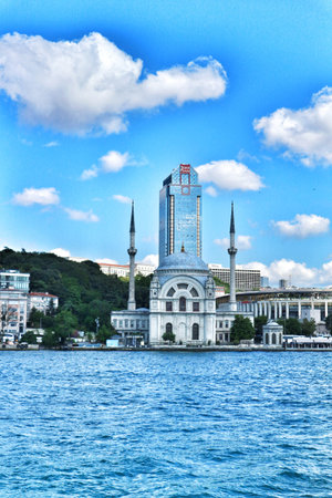 Istanbul, Turkey on 12 July 2022. Picturesque cityscape featuring a mosque and modern building complex situated on the waterfront under a bright, cloudy sky Great for travel or architectural themes.のeditorial素材