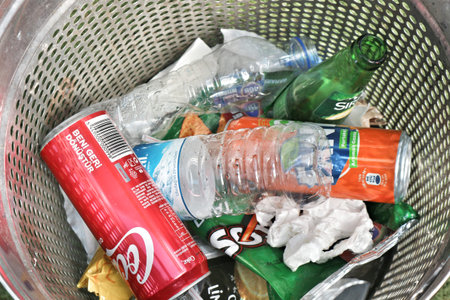 Istanbul, Turkey on 12 July 2022. Metal trash can is overflowing with bottles, cans, and snack wrappers, highlighting waste management issues Great for illustrating concepts of recycling and environmental responsibility.のeditorial素材